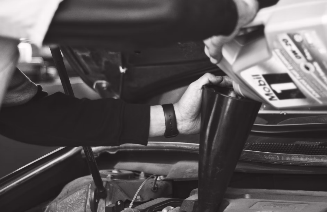A J&E technician adding engine oil